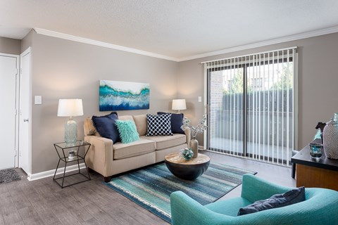 A living room with a couch, a chair, and a painting on the wall.