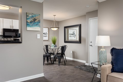 A modern dining room with a glass table and chairs.