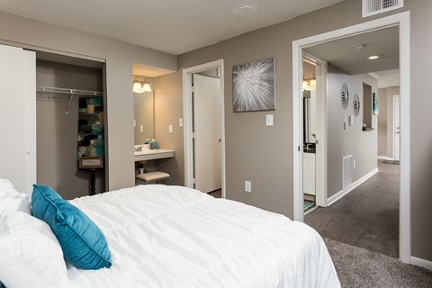 A bedroom with a white bed and a blue pillow.