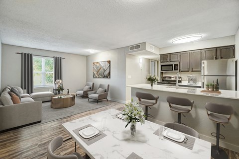 A modern living room with a dining area and kitchen in the background.