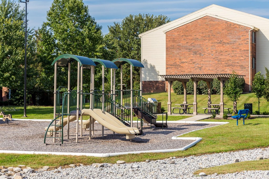 A playground with a slide and a green canopy.