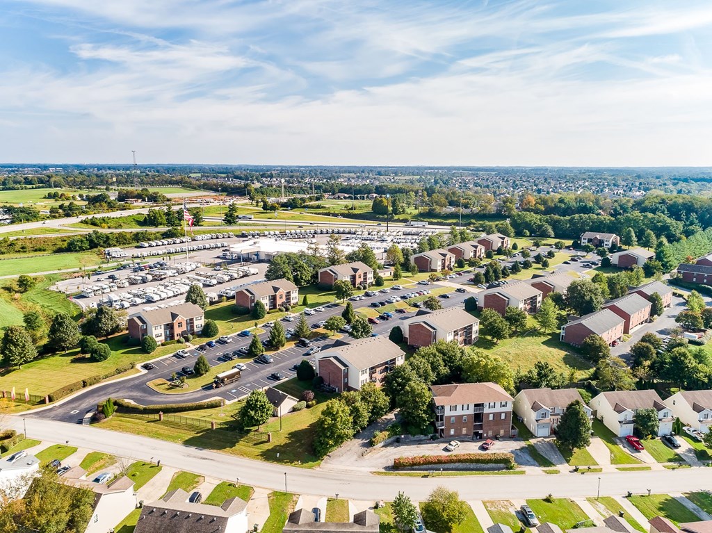 A bird's eye view of a residential area with houses and a parking lot.