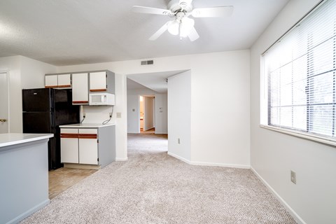 A kitchen with white cabinets and a black fridge is seen.