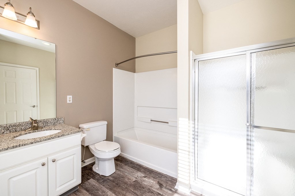 bathroom with vanity, toilet, shower, and bathtub