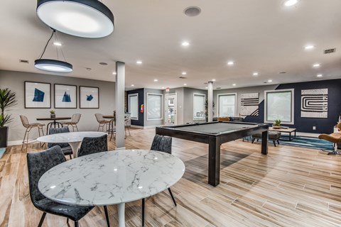 A modern dining room with a round marble table and chairs.