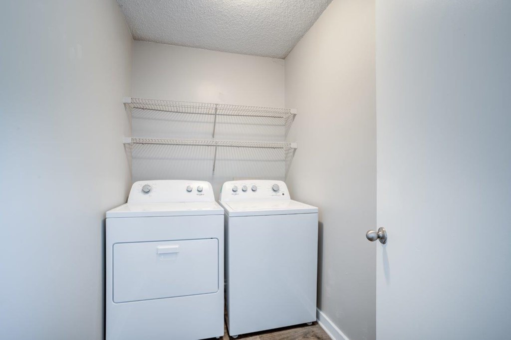 Two white front loading washing machines in a laundry room.