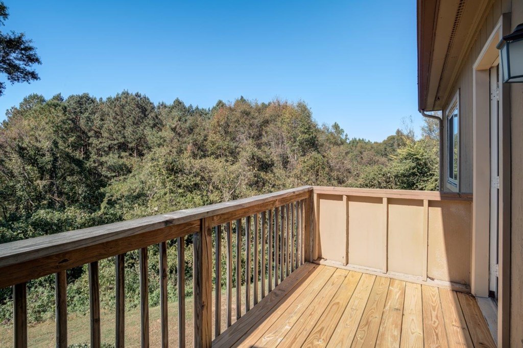 A wooden deck overlooks a forest.