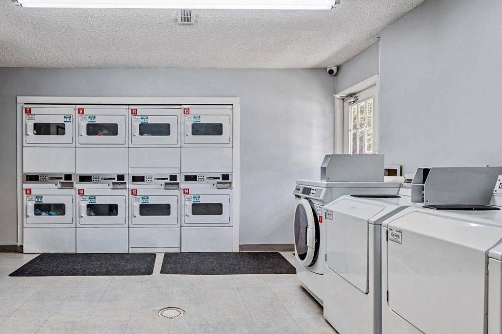 a laundry room with washers and dryers and a row of machines
