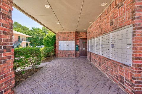 A long hallway with mailboxes on the wall.