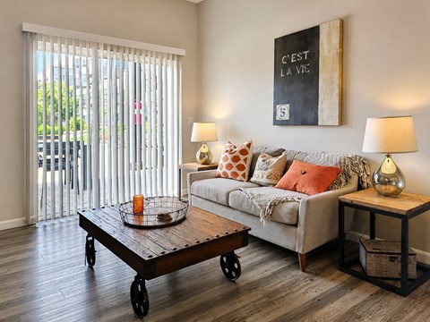 A living room with a couch, a table, and a painting on the wall.