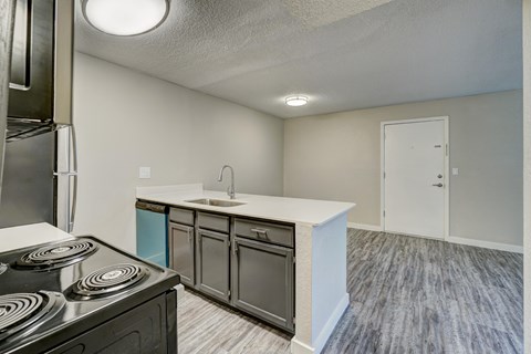 A kitchen with a stove top oven and a sink.