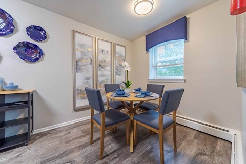 A dining room with a table set for four.