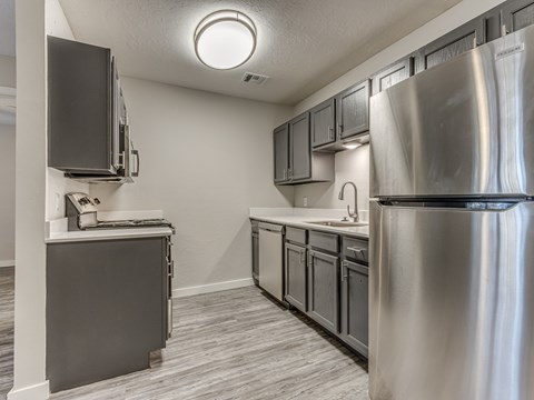 A kitchen with a stainless steel refrigerator and a dishwasher.