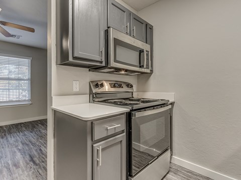 A modern kitchen with a stainless steel oven and microwave.