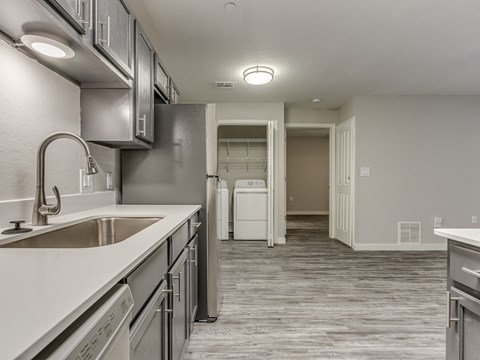 A modern kitchen with stainless steel appliances and a white countertop.