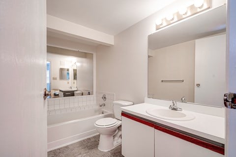 A white bathroom with a toilet, sink, and bathtub.