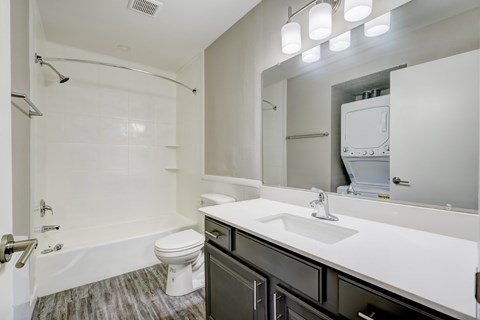 A white toilet sits in a white bathroom next to a sink.