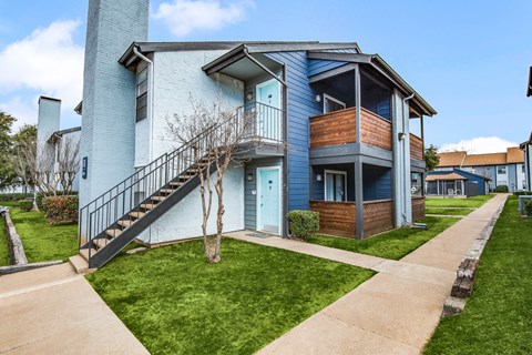 A blue two-story house with a black metal staircase.
