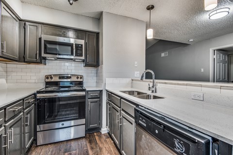 A modern kitchen with a stove top oven and a microwave.