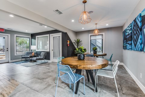A modern dining room with a round wooden table and chairs.