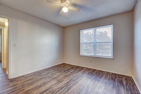 A room with a window and a ceiling fan.