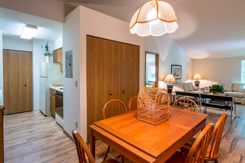 A dining room with a wooden table and chairs.