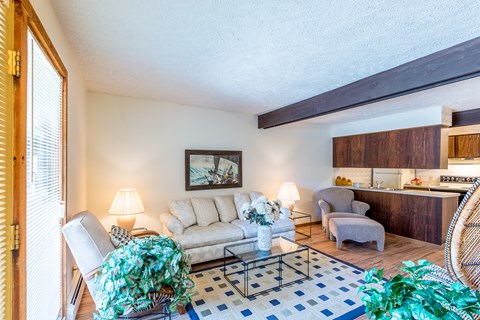 A living room with a white couch, a coffee table, and a painting on the wall.