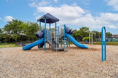 A playground with a blue slide and a blue and white structure.