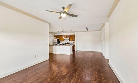 A room with a ceiling fan and wooden floors.