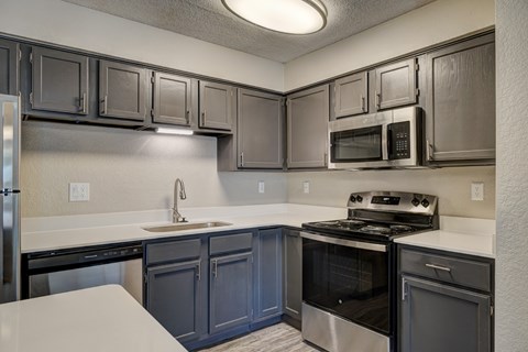 A kitchen with a stove, oven, microwave, and refrigerator.