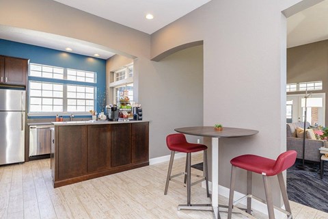 A kitchen with a table and chairs.