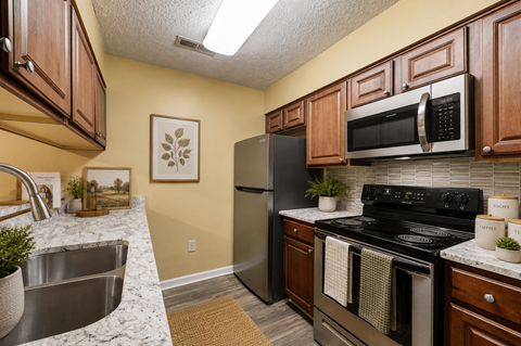A kitchen with a black stove top oven and a black microwave above it.
