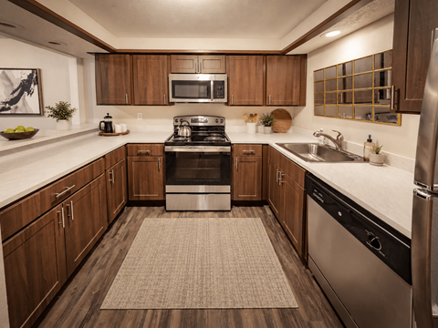 A modern kitchen with wooden cabinets and stainless steel appliances.