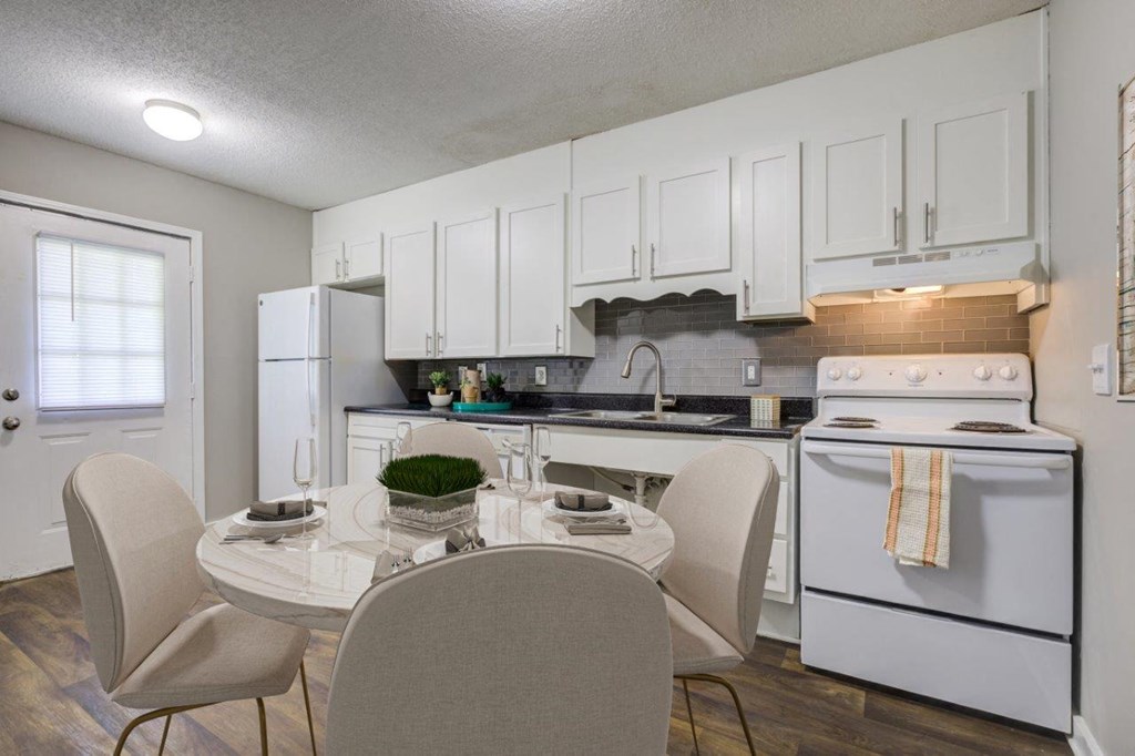 a kitchen with white appliances and a dining table