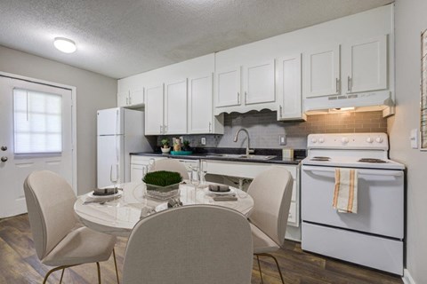 a kitchen with white appliances and a dining table