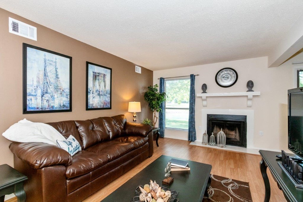 staged living room with hardwood floors and a fireplace