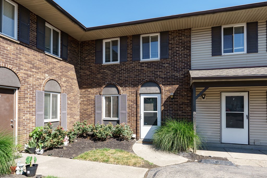 A house with a brown brick exterior and a white door.