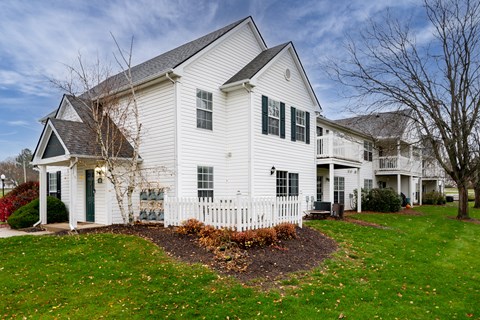 A white house with a black roof and a green door.