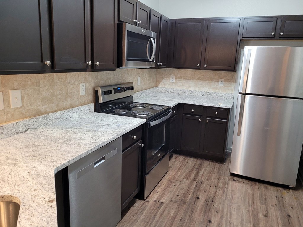 a kitchen with dark cabinets and white countertops