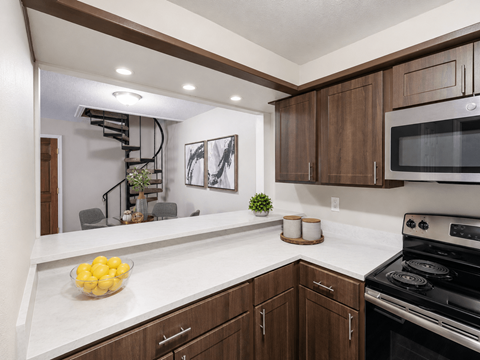 A kitchen with brown cabinets and a black stove top oven.