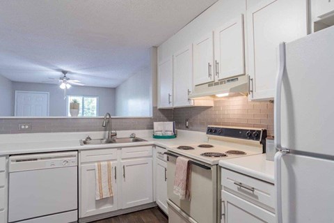 A kitchen with white appliances and cabinets.