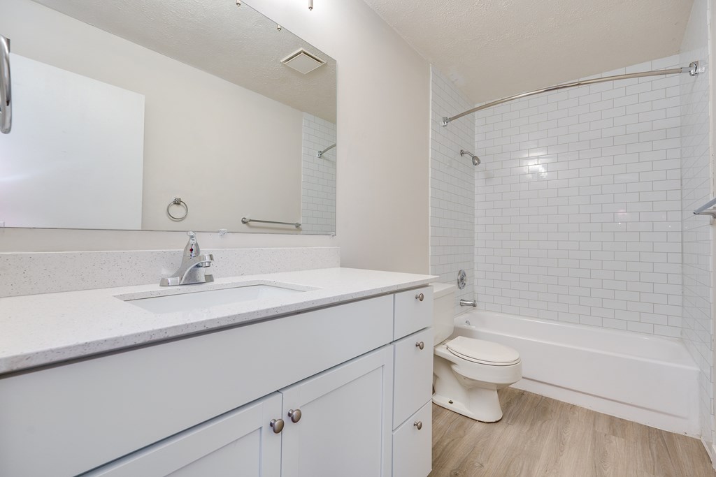 A white bathroom with a sink, toilet, and bathtub.
