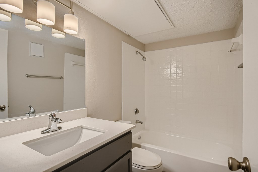 A bathroom with a sink, toilet, and bathtub.