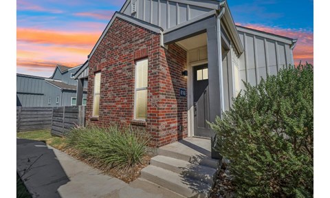 A house with a red brick facade and a grey roof.