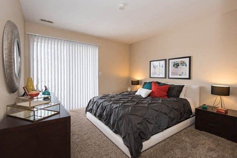 A bedroom with a large bed, a dresser, and a mirror.