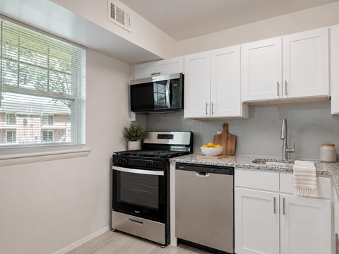 A kitchen with white cabinets and a black stove top oven.