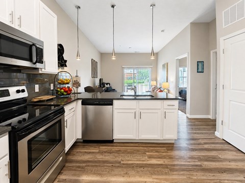 A modern kitchen with a stainless steel oven and white cabinets.