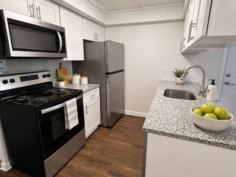 A kitchen with black appliances and white cabinets.