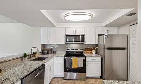 A modern kitchen with stainless steel appliances and granite countertops.