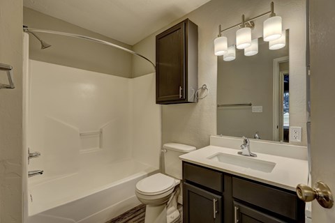 A bathroom with a white sink and toilet.